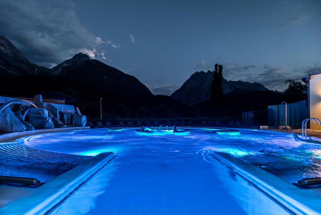 Blick über das beleuchtete Aussenbecken des Bogn Engiadina in der Nacht