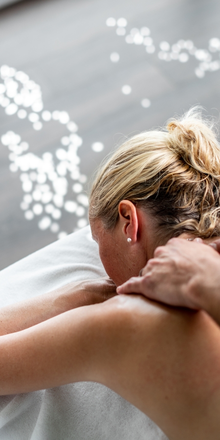 A therapist massages the back of a client